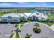 Striking aerial view of the community clubhouse, featuring elegant architecture and beautifully landscaped surroundings at 15719 Barefoot Beach Dr, Lakewood Ranch, FL 34211