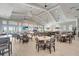 Bright and airy dining area with neutral decor, modern tables, ample seating, large windows, and ceiling fans at 15719 Barefoot Beach Dr, Lakewood Ranch, FL 34211