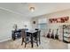 Dining room with textured wall, modern chandelier, marble top table and seating for six at 15719 Barefoot Beach Dr, Lakewood Ranch, FL 34211