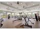 Well-equipped gym featuring modern exercise machines, free weights, large windows, and ample space for workouts at 15719 Barefoot Beach Dr, Lakewood Ranch, FL 34211