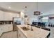 Bright kitchen featuring a large island with sink and stainless steel refrigerator, opening into the dining area at 15719 Barefoot Beach Dr, Lakewood Ranch, FL 34211
