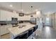 Kitchen boasts granite counters, stainless appliances, a large island, and modern pendant lighting at 15719 Barefoot Beach Dr, Lakewood Ranch, FL 34211