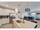 Bright kitchen with granite island, stainless steel appliances, and views of the living area at 15719 Barefoot Beach Dr, Lakewood Ranch, FL 34211