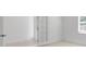 Bright bedroom with white walls, light carpet, a window with blinds, and a door with glass panels at 1599 Laurel Brook Ln, Port Charlotte, FL 33953