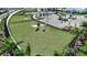 Large community dog park with lush green grass, mature trees, adjacent parking and convenient waste station at 1599 Laurel Brook Ln, Port Charlotte, FL 33953
