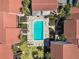 Overhead shot of the community pool surrounded by red tile roofs, landscaping, and lounge chairs at 1624 Stickney Point Rd # 24-206, Sarasota, FL 34231