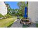 Backyard patio area with brick pavers, lawn, and outdoor cooking and seating area at 1624 Stickney Point Rd # 24-206, Sarasota, FL 34231