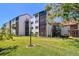 Multi-story exterior with patios and greenery, including palms and green lawn at 1624 Stickney Point Rd # 24-206, Sarasota, FL 34231