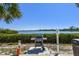 Community grill area with stainless steel gas grill, bay view, and manicured landscaping at 1624 Stickney Point Rd # 24-206, Sarasota, FL 34231