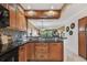 Kitchen boasts wooden cabinets, black appliances, and granite countertops at 1624 Stickney Point Rd # 24-206, Sarasota, FL 34231