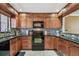 Kitchen boasts wooden cabinets, black appliances, and granite countertops at 1624 Stickney Point Rd # 24-206, Sarasota, FL 34231