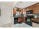 Cozy kitchen featuring black appliances, wooden cabinets, and granite countertops at 1624 Stickney Point Rd # 24-206, Sarasota, FL 34231