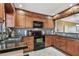 Kitchen boasts wooden cabinets, black appliances, and granite countertops at 1624 Stickney Point Rd # 24-206, Sarasota, FL 34231