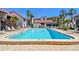 Community pool with a clear blue swimming area surrounded by lounge chairs on a bright, sunny day at 1624 Stickney Point Rd # 24-206, Sarasota, FL 34231