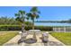 Community seating area with a decorative tile table and bench seats with a view of the bay and manicured landscaping at 1624 Stickney Point Rd # 24-206, Sarasota, FL 34231