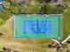 Aerial view of a well-maintained tennis court in a sunny community with lush green grass and palm trees at 1624 Stickney Point Rd # 24-206, Sarasota, FL 34231