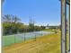 A view of the tennis court showcases professional quality turf, and lush landscaping at 1624 Stickney Point Rd # 24-206, Sarasota, FL 34231