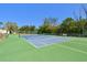 Tennis courts surrounded by green grass and trees with blue sky above at 1624 Stickney Point Rd # 24-206, Sarasota, FL 34231