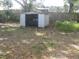 Backyard featuring a shed, scattered leaves, and a wooden fence at 1805 9Th W St, Palmetto, FL 34221