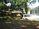 Spacious backyard with mature trees, a wooden fence, and a small deck area at 1805 9Th W St, Palmetto, FL 34221