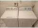 Laundry room featuring a white washer and dryer set on tiled floor at 1805 9Th W St, Palmetto, FL 34221