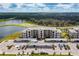 An aerial view of the condos with covered parking, green space, lake and golf course in the background at 18114 Gawthrop Dr # 306, Bradenton, FL 34211