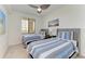 Bedroom with two beds, window, ceiling fan, and nautical decor at 18114 Gawthrop Dr # 306, Bradenton, FL 34211
