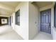 A gray front door with unit number on an outdoor hallway that has a view of an opening to the outside at 18114 Gawthrop Dr # 306, Bradenton, FL 34211