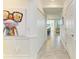 Long hallway with three closets, tile floors, white walls, and a frog art piece in a white frame on the wall at 18114 Gawthrop Dr # 306, Bradenton, FL 34211