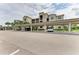 Covered parking spaces next to landscaping and condo buildings with cars parked and a light colored street at 18114 Gawthrop Dr # 306, Bradenton, FL 34211
