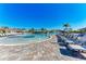 Sprawling pool area featuring many lounge chairs, umbrellas, and palm trees on a sunny day at 18114 Gawthrop Dr # 306, Bradenton, FL 34211