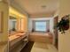 Bathroom featuring a vanity with Hollywood lighting, a tub with tile surround, and neutral decor at 18513 Placid Ave, Port Charlotte, FL 33948