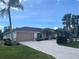 Charming single-story home with a spacious driveway, lush landscaping, and a well-maintained lawn at 18513 Placid Ave, Port Charlotte, FL 33948