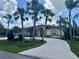 Charming single-story home featuring a well-manicured lawn, mature palm trees, and a circular driveway at 18513 Placid Ave, Port Charlotte, FL 33948