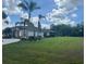 Well-maintained single Gathering home with a large manicured front yard with palm trees at 18513 Placid Ave, Port Charlotte, FL 33948