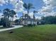 Well-maintained single Gathering home with a large manicured front yard with palm trees at 18513 Placid Ave, Port Charlotte, FL 33948