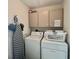 Bright laundry room featuring updated washer, dryer, and storage cabinets at 18513 Placid Ave, Port Charlotte, FL 33948