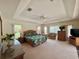 Spacious main bedroom featuring a tray ceiling, multiple windows, and comfortable seating area at 18513 Placid Ave, Port Charlotte, FL 33948