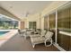 A view of an outdoor patio with a dining area and lounge chairs with access to the pool area at 18513 Placid Ave, Port Charlotte, FL 33948