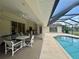 A beautiful screened-in pool area with an outdoor dining table and chairs at 18513 Placid Ave, Port Charlotte, FL 33948