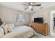 Comfortable bedroom with a ceiling fan, dresser, and a window that provides natural light at 206 Bedford St, Oldsmar, FL 34677