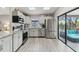 Modern kitchen with stainless appliances, white cabinets, and sliding glass doors leading to outdoor space at 206 Bedford St, Oldsmar, FL 34677