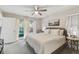 Comfortable main bedroom with neutral tones, a ceiling fan, and access to a private outdoor patio at 206 Bedford St, Oldsmar, FL 34677