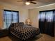Comfortable main bedroom featuring two windows, ceiling fan and plush bed at 22116 26Th E Ave, Bradenton, FL 34211