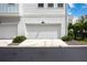 Clean, white garage door and driveway enhanced by lush landscaping and curb appeal at 2344 Lindstrom St, Sarasota, FL 34237