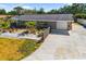 An aerial view of the home showcasing its long driveway, lush landscaping, and new roof at 2929 Siesta Dr, Venice, FL 34293