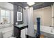 Bathroom featuring a unique sink, mirror and a shower with a gray curtain and blue decorative column at 2929 Siesta Dr, Venice, FL 34293