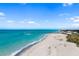 An aerial view of a scenic beach featuring soft sand, the ocean and a pier extending out into the turquoise water at 2929 Siesta Dr, Venice, FL 34293