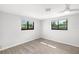 Bright bedroom with wood flooring, two windows, and a ceiling fan provides plenty of natural light at 2929 Siesta Dr, Venice, FL 34293