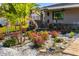 Charming landscaped front yard with tropical plants, flowers, white gravel, and a wooden walkway leading to the house at 2929 Siesta Dr, Venice, FL 34293